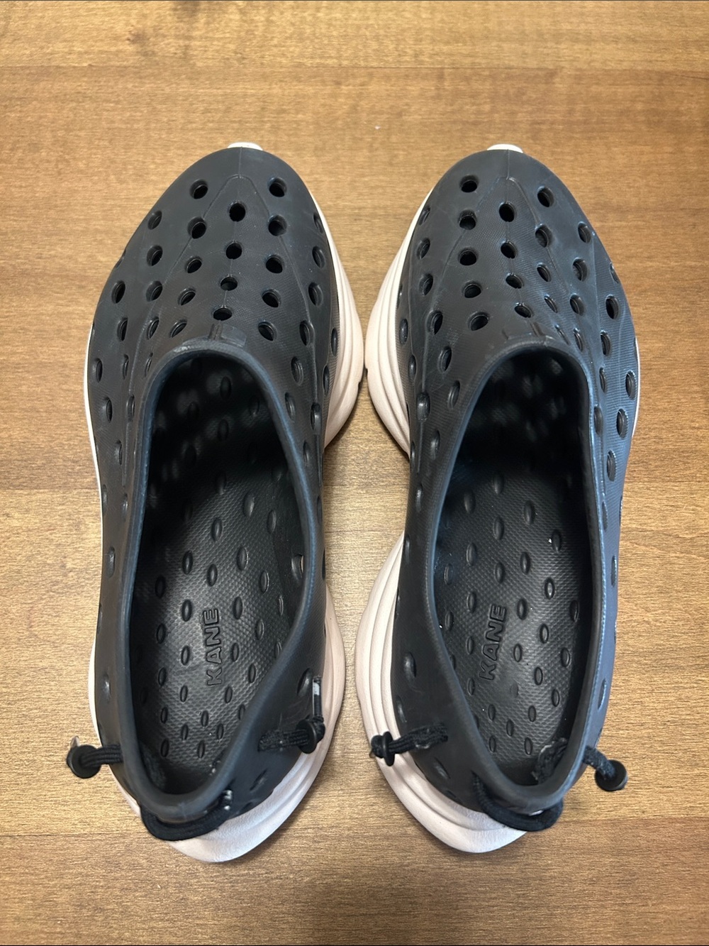 Womenโs Perforated Slip-On Sandals in Black and Cream